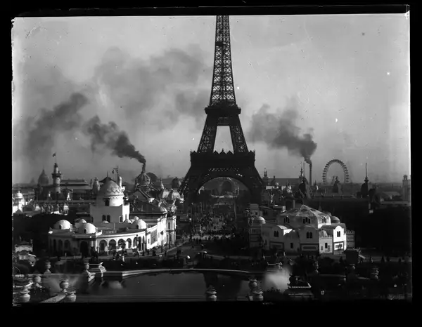 Photographie prise depuis la Colline de Chaillot. Au premier plan bassin des jardins du Trocadéro, au second plan à gauche et à droite de la voie centrale les d